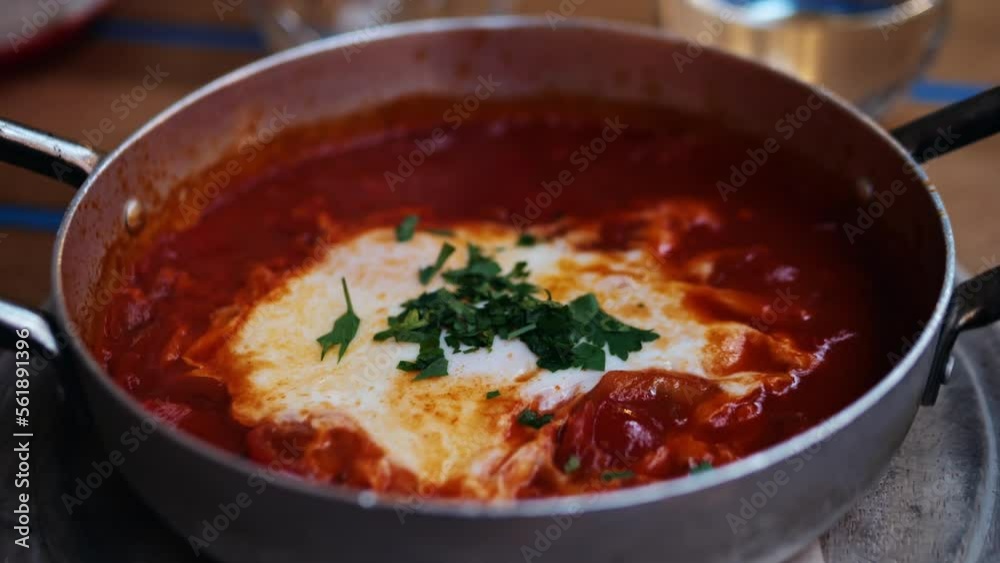 Shakshuka in iron frying pan in Israel cafe. Typical breakfast traditional food in Israel, Middle Eastern kitchen. . Shakshuka in iron frying pan in Israel cafe. Typical breakfast traditional food in Israel, Middle Eastern kitchen. .