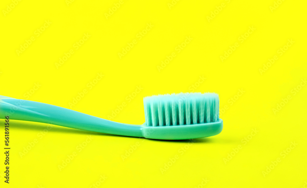 Turquoise toothbrush on yellow background Turquoise toothbrush on yellow background