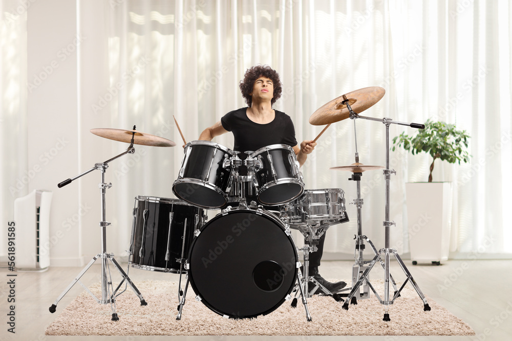 Young man playing drums at home