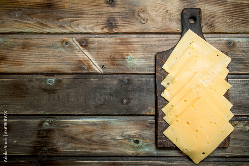Thin slices of cheese on the cutting Board.