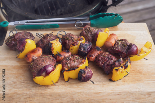 ready to eat - skewers from venison with yellow paprika and red onions grilled at outdoor on a charcoal grill