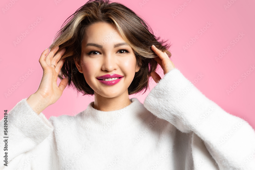 A positive young woman with a stylish short bob haircut and a light natural colouring. Beautiful Asian girl with flared hair looks into the camera and smiles against a pink background A positive young woman with a stylish short bob haircut and a light natural colouring. Beautiful Asian girl with flared hair looks into the camera and smiles against a pink background