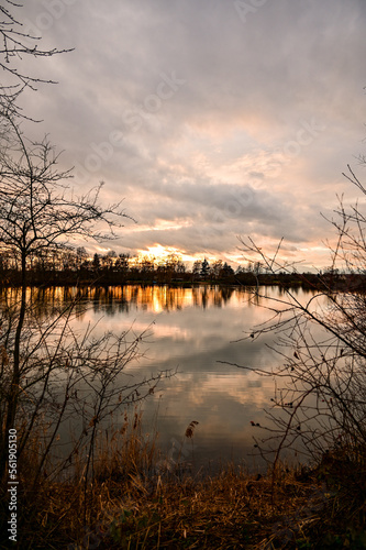 See bei Sonnenuntergang mit Spiegelung der Sonne und Bäume im Wasser, Grafenrheinfeld bei Schweinfurt, Franken, Bayern, Deutschland