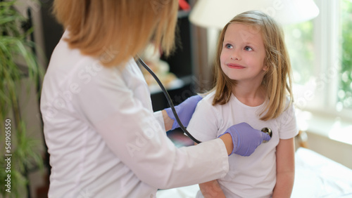 Doctor examines girl in medical office with stethoscope. concept.
