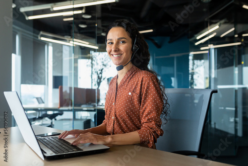 Εκτύπωση καμβά Portrait of Latin American business woman, office worker looking at camera and smiling, using headset and laptop for remote online communication, customer support tech call center worker