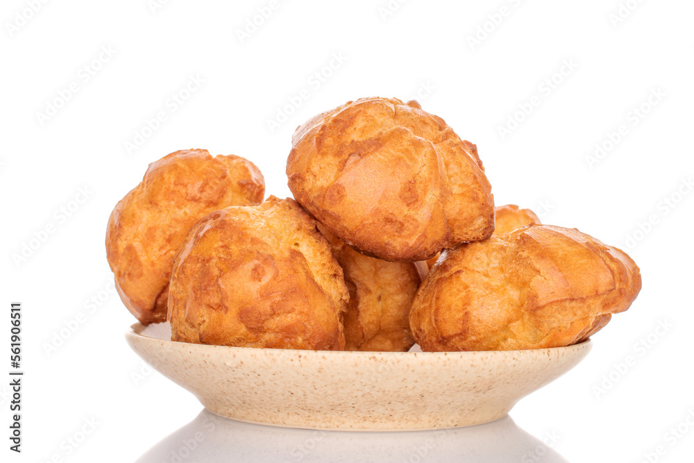 Tasty chouquettes with cream on a saucer, on a white background.