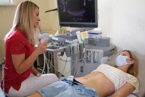 Female patient having ultrasound scanning examination by doctor at hospital.