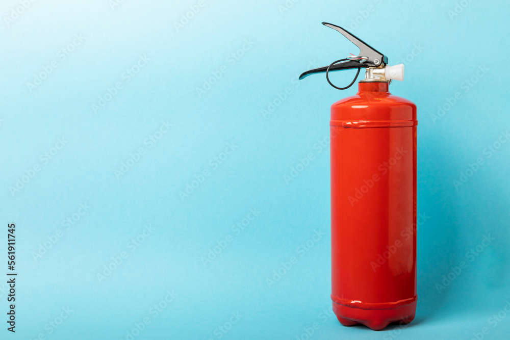 Fire extinguisher on the background of a blue wall. Fire protection, home fire extinguisher. home security concept. Place for text. Copy sleep. Fire extinguisher on the background of a blue wall. Fire protection, home fire extinguisher. home security concept. Place for text. Copy sleep.