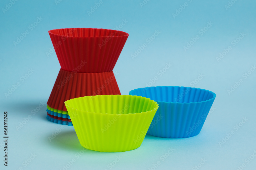 Set of new colorful silicone baking molds on blue paper background Set of new colorful silicone baking molds on blue paper background