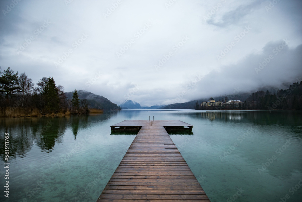 Wooden pier with clear lake in the Alps in summer, Wooden pier at Lake Fuschlsee in summer, Salzburg, Austria Wooden pier with clear lake in the Alps in summer, Wooden pier at Lake Fuschlsee in summer, Salzburg, Austria