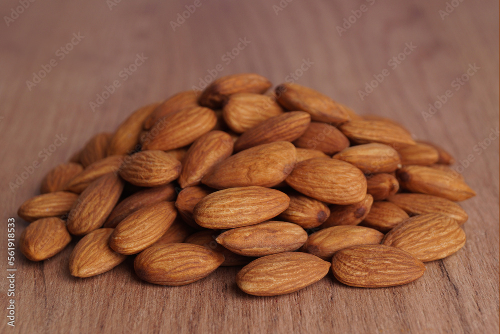 Pile of delicious almonds on wooden table, closeup Pile of delicious almonds on wooden table, closeup