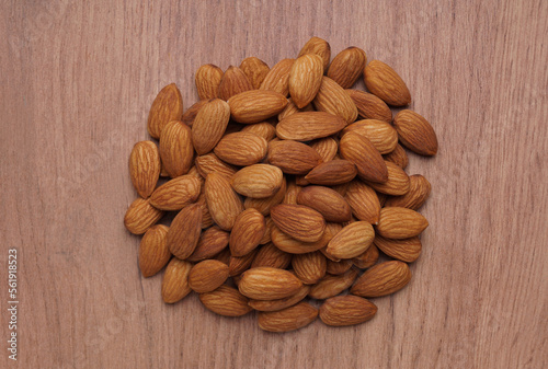 Pile of delicious almonds on wooden table, top view