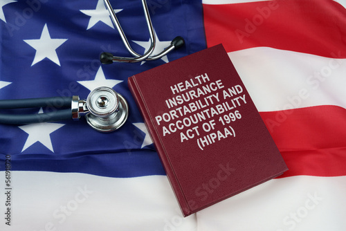 On the US flag lies a stethoscope and a book with the inscription - Health Insurance Portability and Accountability Act photo