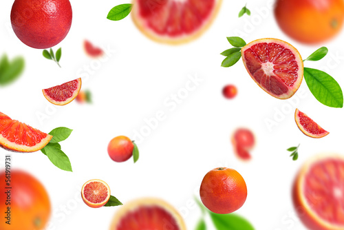 Fototapeta Naklejka Na Ścianę i Meble -  Red oranges with green leaves flying on white background