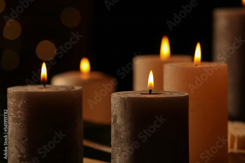 Closeup view of burning candles against blurred festive lights