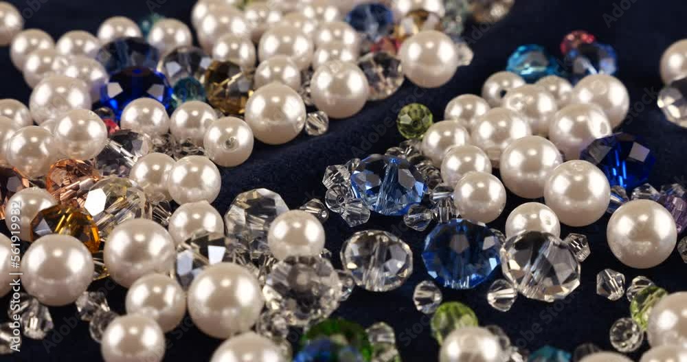 Transparent white and multi-colored jewelry crystals, rhinestones and pearls on blue velvet.