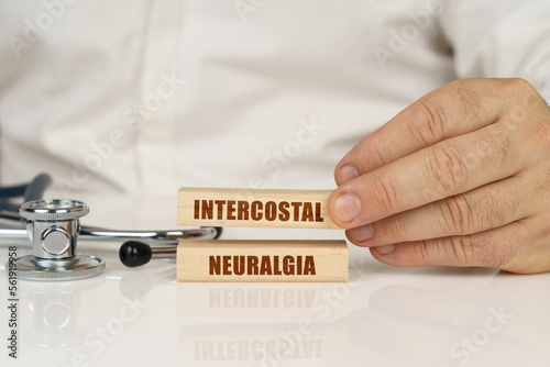 On a white surface, a stethoscope and wooden plates with the inscription - intercostal neuralgia photo