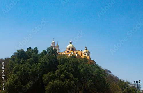 Church of Cholula, Puebla, Mexico. Yellow Church on a mountain with a blue sky in the background. (ID: 561920160)