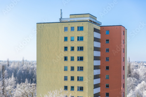 Buntes Wohnhochhaus mit Winterlandschaft im Hintergrund (ID: 561921188)