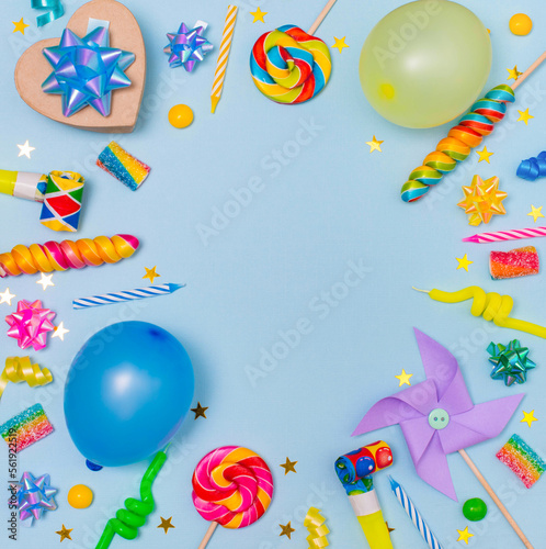 Child birthday party border on blue background with copy space. Baloons, candles, candies, gift boxes.