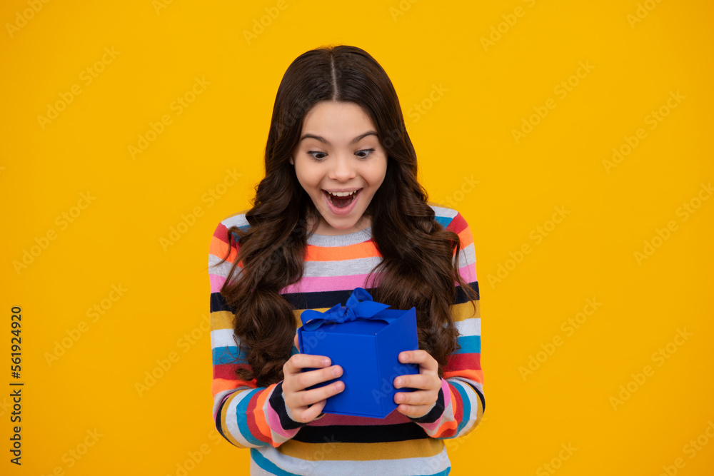 Amazed teenager. Child teen girl 12-14 years old with gift on yellow isolated background. Birthday, holiday present concept. Excited teen girl. Amazed teenager. Child teen girl 12-14 years old with gift on yellow isolated background. Birthday, holiday present concept. Excited teen girl.