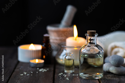 Spa setting with essential oil  candle  sea salt  pebbles  towel on dark wooden background. Massage  aromatherapy. Natural organic ingredients for relaxation  detention. Wellness in salon concept