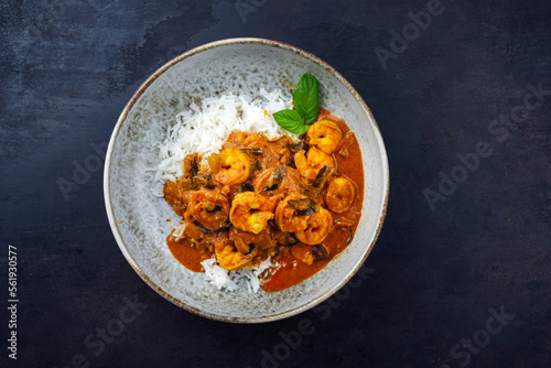 Traditional spicy Indian prawn Madras curry Rogan Josh with king prawns and basmati rice served as top view in a Nordic design bowl with copy space photo