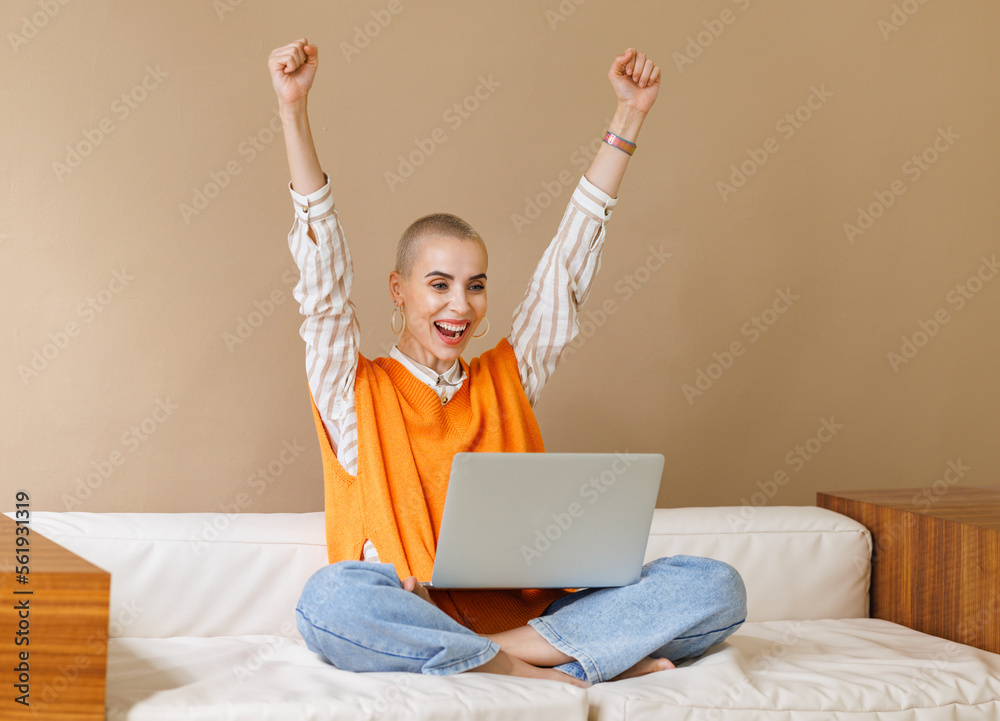 Beautiful female entrepreneur freelancer with very short hair celebrating success Beautiful female entrepreneur freelancer with very short hair celebrating success