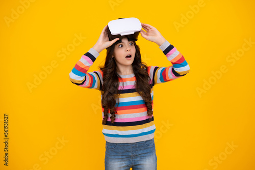 Excited teenager using VR headset. Girl play vr video game. Digital future and innovation. Child in virtual goggles. Excited teen girl with virtual reality goggles headset isolated on yellow.