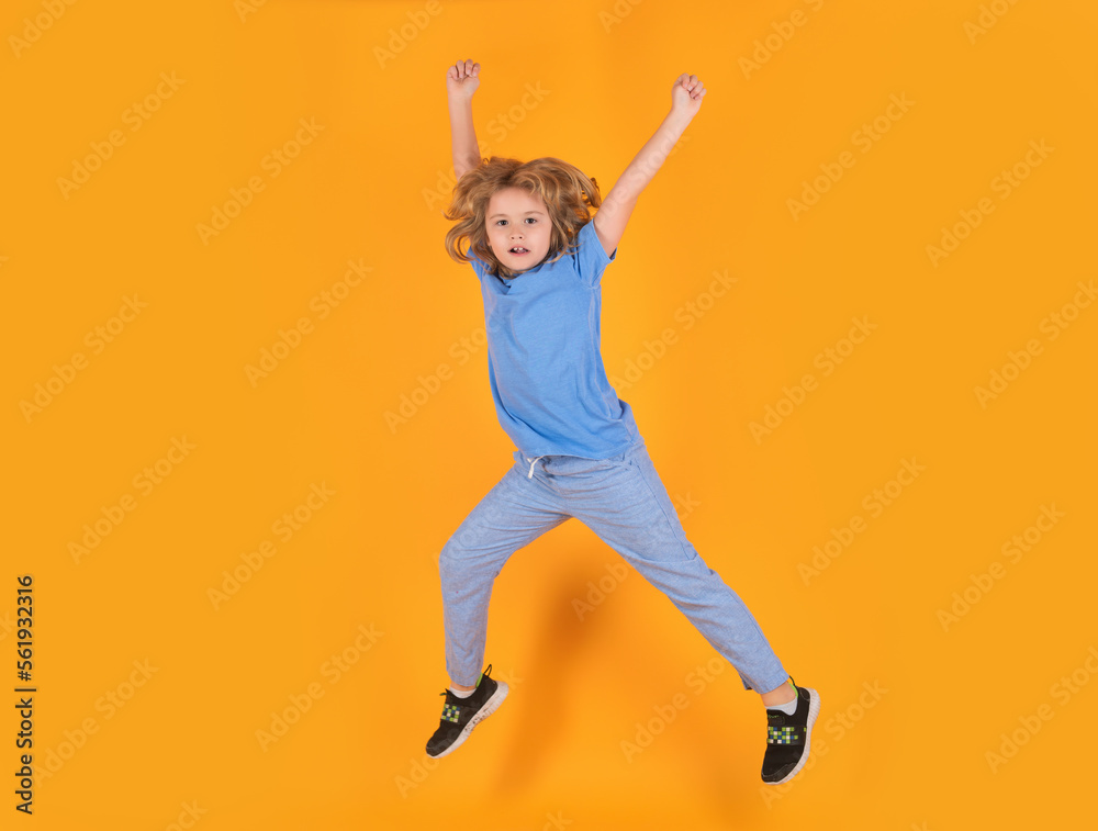 Fototapeta premium Boy jumping. Full size of kid boy have fun jump up isolated over yellow background.