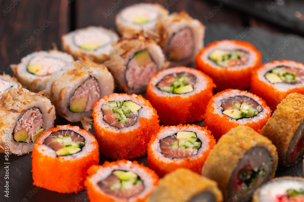 Rolls set with fish shrimp and caviar sushi with chopsticks - asian food and japanese cuisine concept Rolls set with fish shrimp and caviar sushi with chopsticks - asian food and japanese cuisine concept