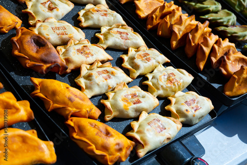 Colorful appetizing Empanadas on display in spanish street cafe photo