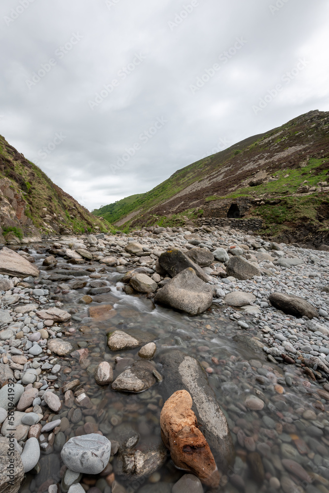 Long exposure of the river Heddon flowing onto the beach at Heddons Mouth in Exmoor National Park