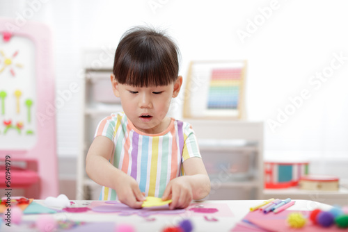 young girl making paper craft for homeschooling