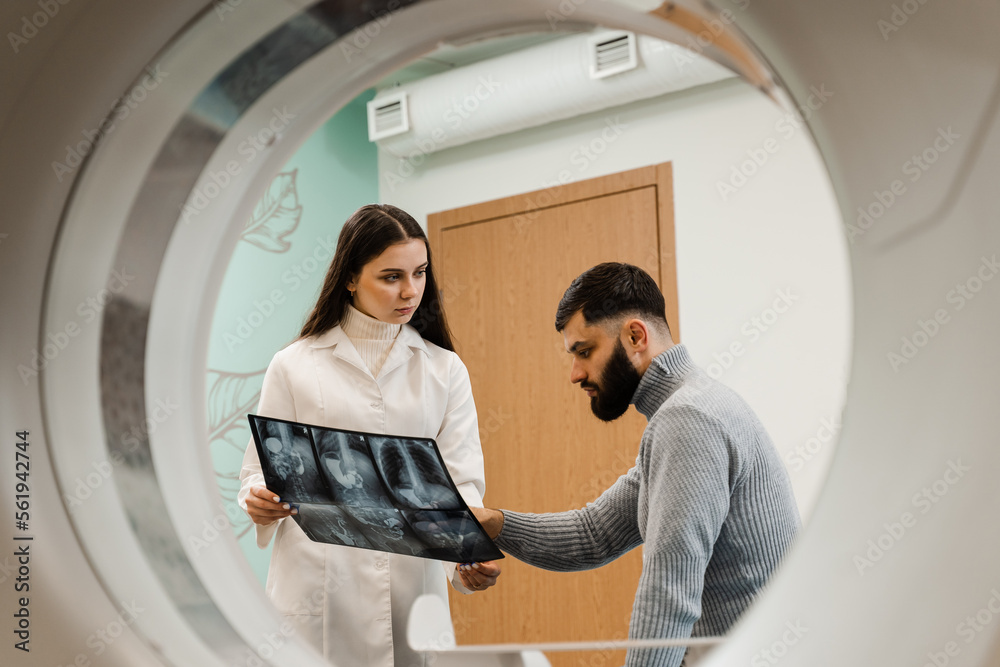 CT scan radiologist showing xray of abdomen to man patient in computed