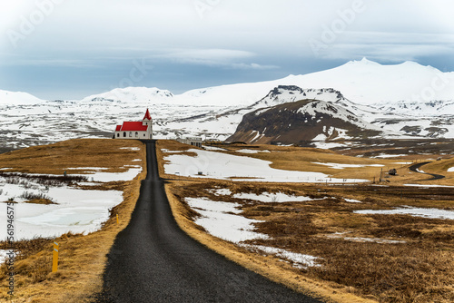 Road leading towards the small church of Ingjaldshóll, the Ingjaldshólskirkja, with the snow-covered Snæfellsjökull glacier in the background, near Hellissandur, Snæfellsnes, Iceland