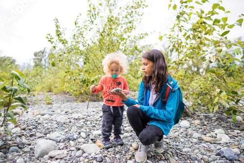 Girl showing toddler rock while hiking photo