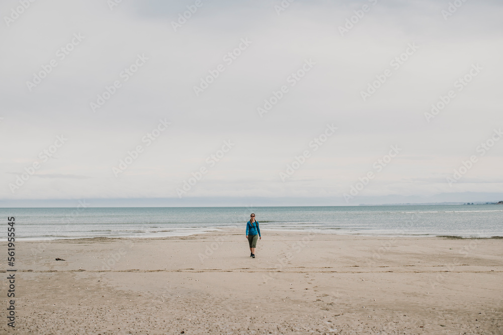 female walks alone on beach Abel Tasman National Park New Zealand female walks alone on beach Abel Tasman National Park New Zealand