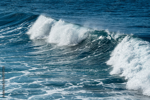 Full frame shot of the deep blue Atlantic Ocean and a beautiful wave crashing on the coast of Paul do Mar, a popular surf spot on Madeira island, Portugal