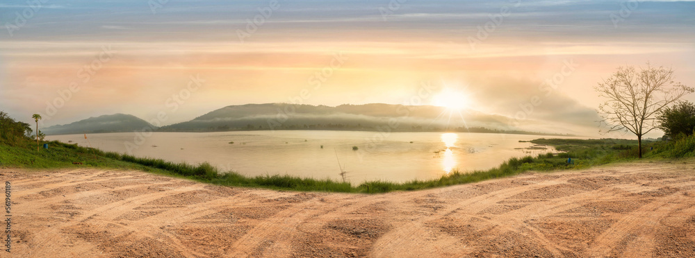 Fototapeta premium Empty dry cracked swamp reclamation soil, land plot for housing construction project with car tire print in rural area and beautiful blue sky with fresh air Land for sales landscape concept