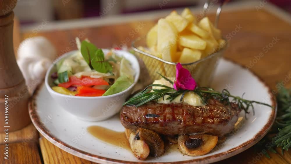 Beautifully served loin steak with salad and French fries in a metal basket. Food and nutrition concert. Meat eaters diet. High quality 4k footage Beautifully served loin steak with salad and French fries in a metal basket. Food and nutrition concert. Meat eaters diet. High quality 4k footage
