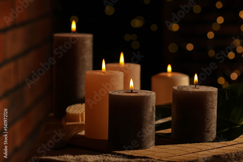 Spa composition with burning candles on massage table in wellness canter