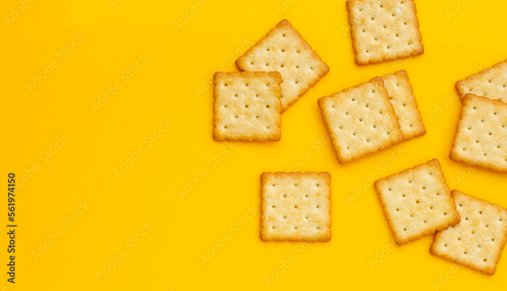 Dry cracker cookies on yellow background.
