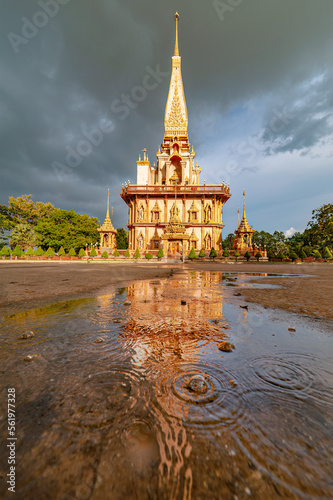 Beautiful golden rain drops and water ripples with reflection of Chaithararam Temple (Wat Chalong). The temple is the historical landmark in Phuket, Thailand. photo