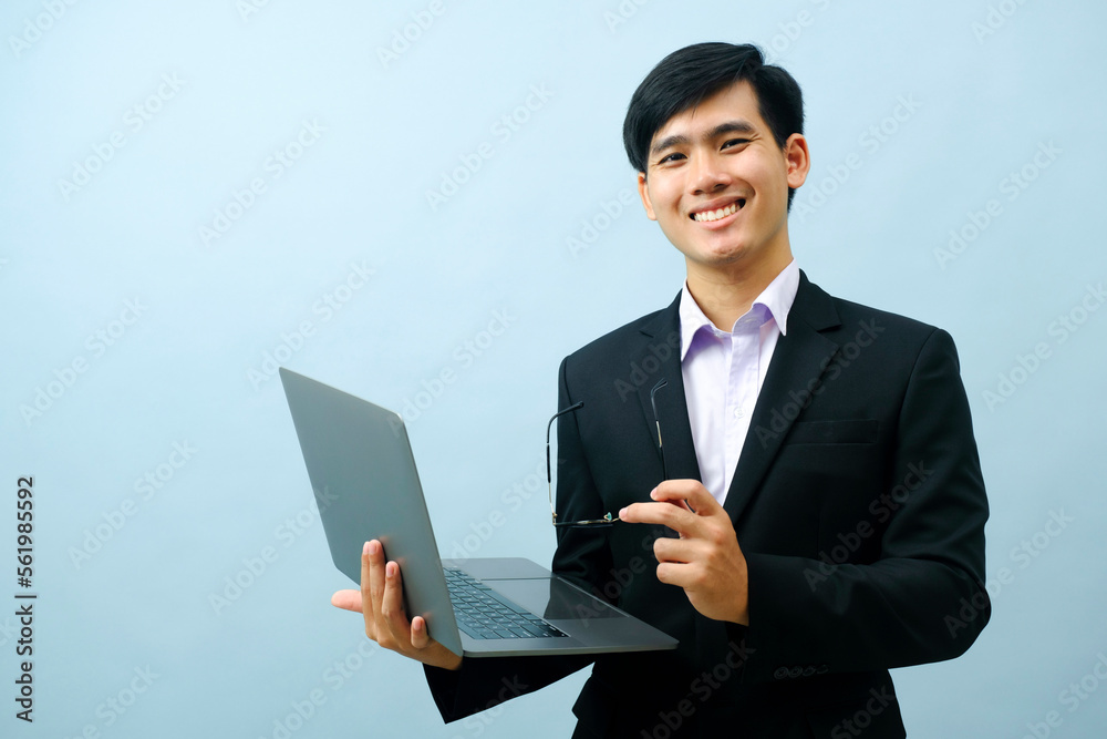 Portrait of businessman using laptop while standing. Portrait of businessman using laptop while standing.