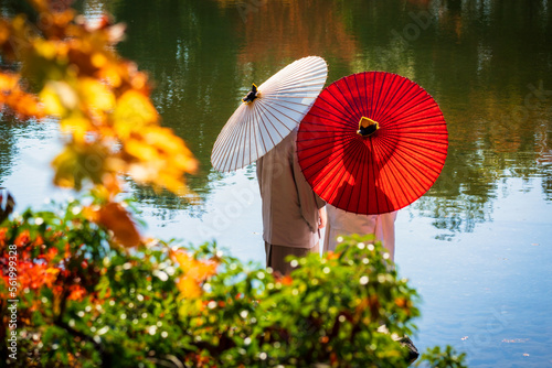 A couple in kimono standing by the pond.