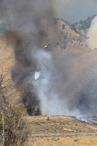 helicopter fire fighting dumping bucket on wildfire 