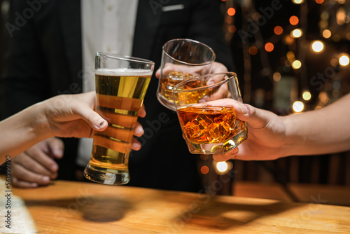 food and drink male friends are happy drinking beer and clinking glasses at a bar or pub.