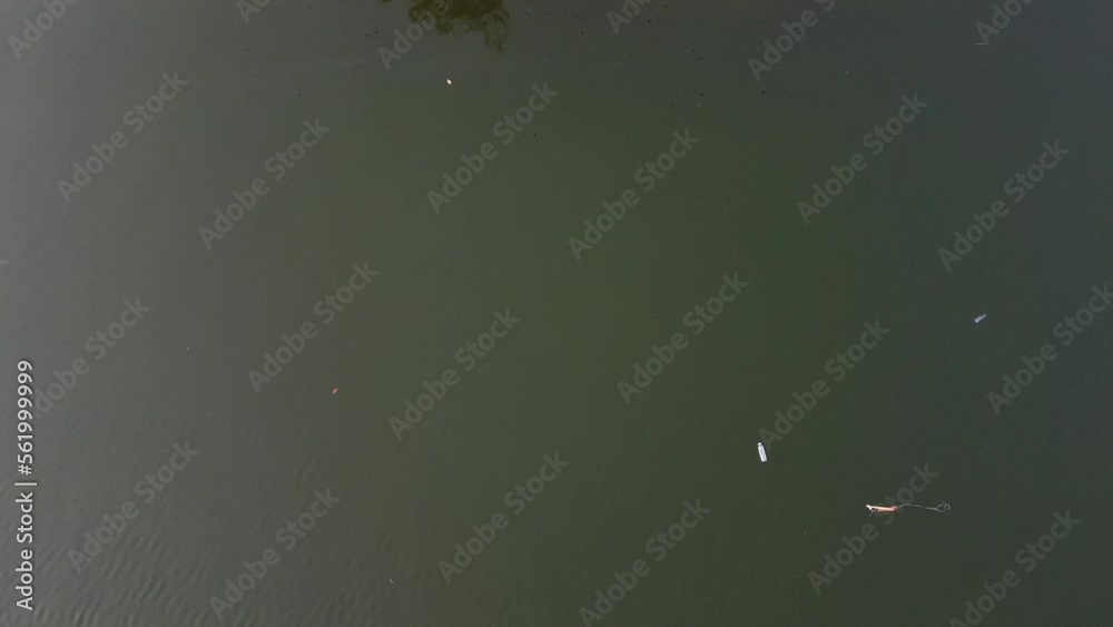 Aerial tracking view of a plastic bottle floating on a dirty river or ocean. Aerial tracking view of a plastic bottle floating on a dirty river or ocean.