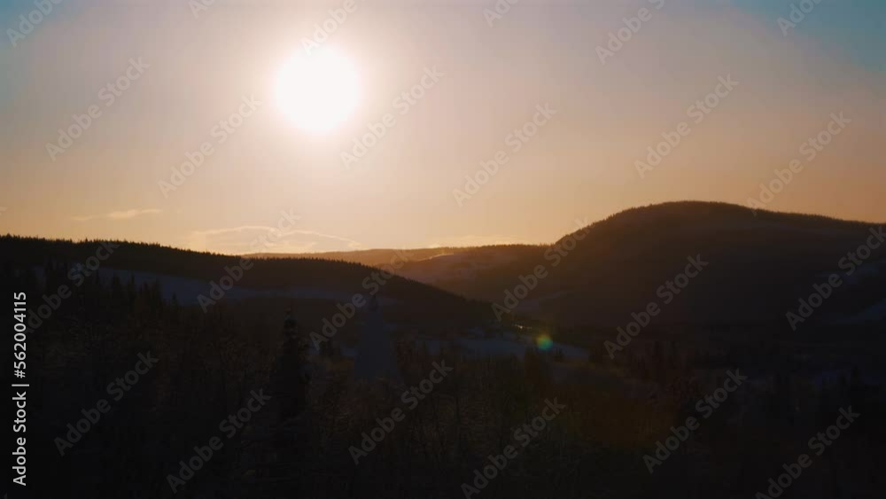 Beautiful orange sunlight at sky over snowy mountain range silhouette in Norway - Wide shot Beautiful orange sunlight at sky over snowy mountain range silhouette in Norway - Wide shot